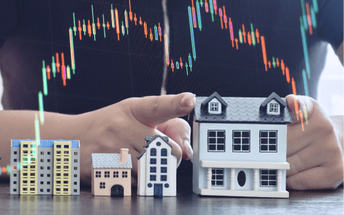 Persona eligiendo una propiedad en planos a escala reflejando la inversion inmobiliaria en planos con gráficos que indican la valorización en el tiempo.